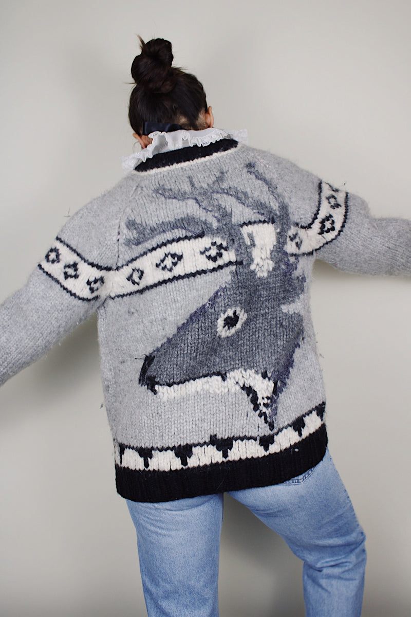 vintage 1970's long sleeve wool zip up cowichan cardigan in grey, white, and black with a deer design on the back