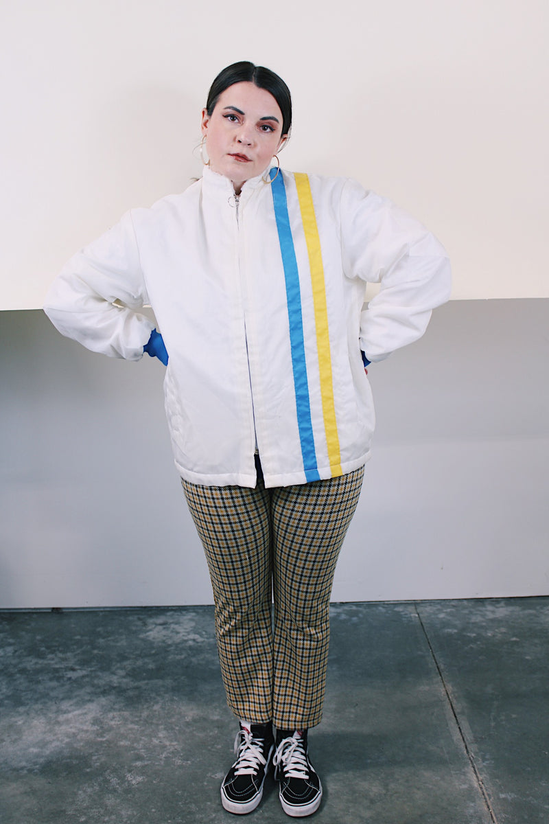 Men's or women's vintage 1970's long sleeve white nylon material zip up windbreaker jacket with a yellow and blue strip on one side. Has patches, pockets, and faux fur body liner.