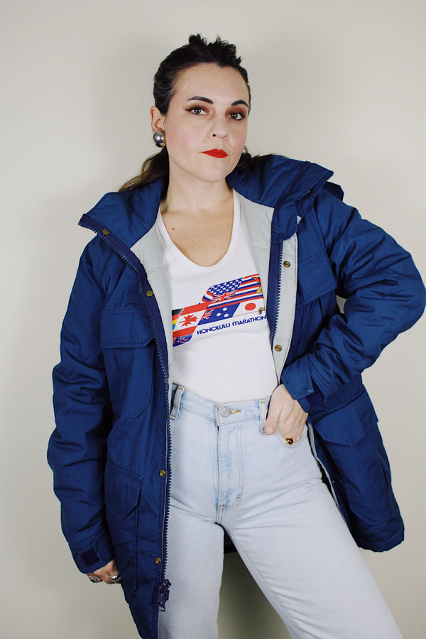 vintage 1980's Woolrich, Made in USA label long sleeve dark blue zip up parka jacket with removable hood, four front velcro pockets, and brass popper buttons