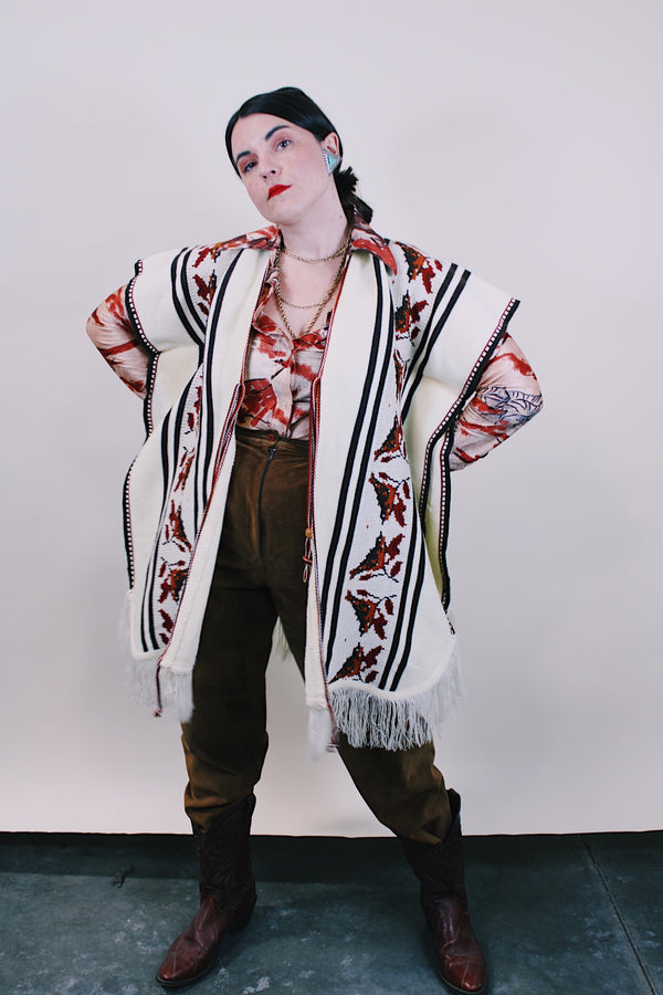 Women's vintage western style 1970's knee length cream colored blanket vest. Sleeveless with tassel closure and fringe trim. Bird and leaf print.