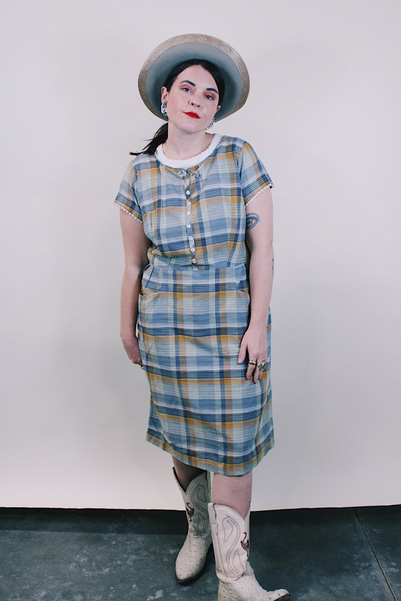 Women's vintage western style 1960's short sleeve midi length plaid print shift dress with white scalloped trim. Grey, teal, and mustard yellow colors.