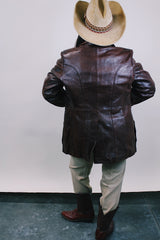 Men's or Women's western style vintage 1980's Fantastic International, Fashions From The World label long sleeve chocolate brown leather button up jacket with pointy double lapel and pockets.