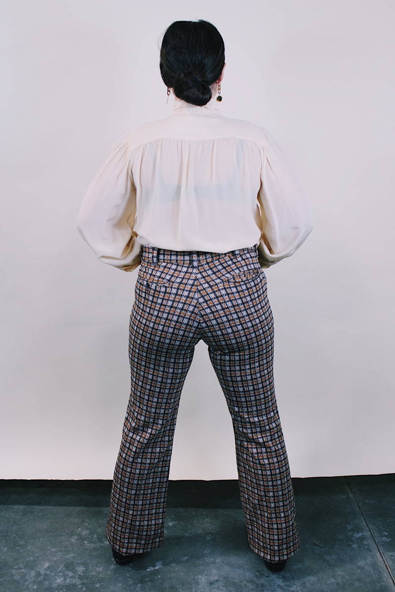Women's or men's vintage western style 1970's polyester material brown plaid pants in chocolate brown, tan, and white. Four pockets, belt loops, and zipper closure with slight bell bottoms. 