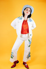 white jacket and pant set with floral embroidery throughout vintage women's 1970's
