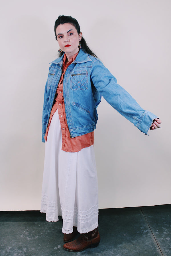 Women's or men's vintage western style 1970's Britannia Sportswear label long sleeve medium wash denim zip up jacket with chest pockets, side pockets, and contrast stitching