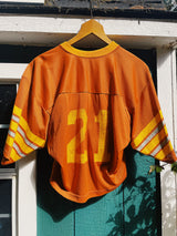 short sleeve burnt orange cropped football jersey with yellow stripes, wording, and trim vintage 1970's