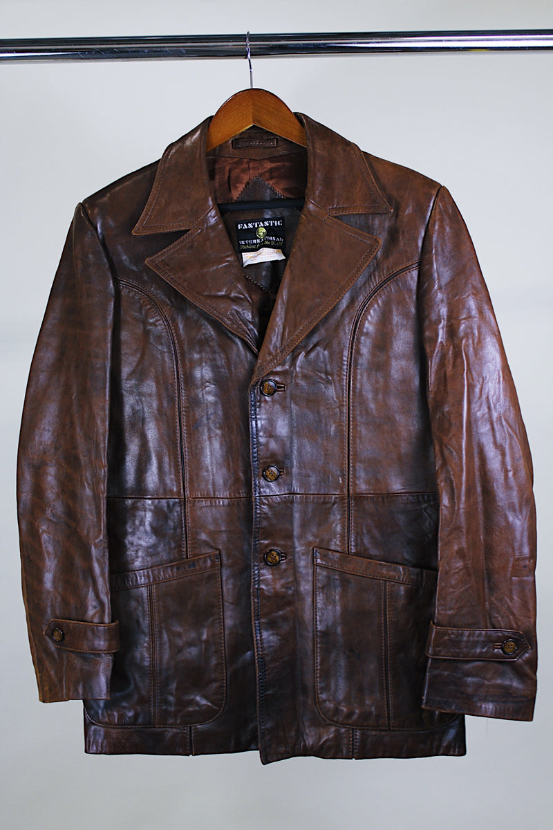 Men's or Women's western style vintage 1980's Fantastic International, Fashions From The World label long sleeve chocolate brown leather button up jacket with pointy double lapel and pockets.