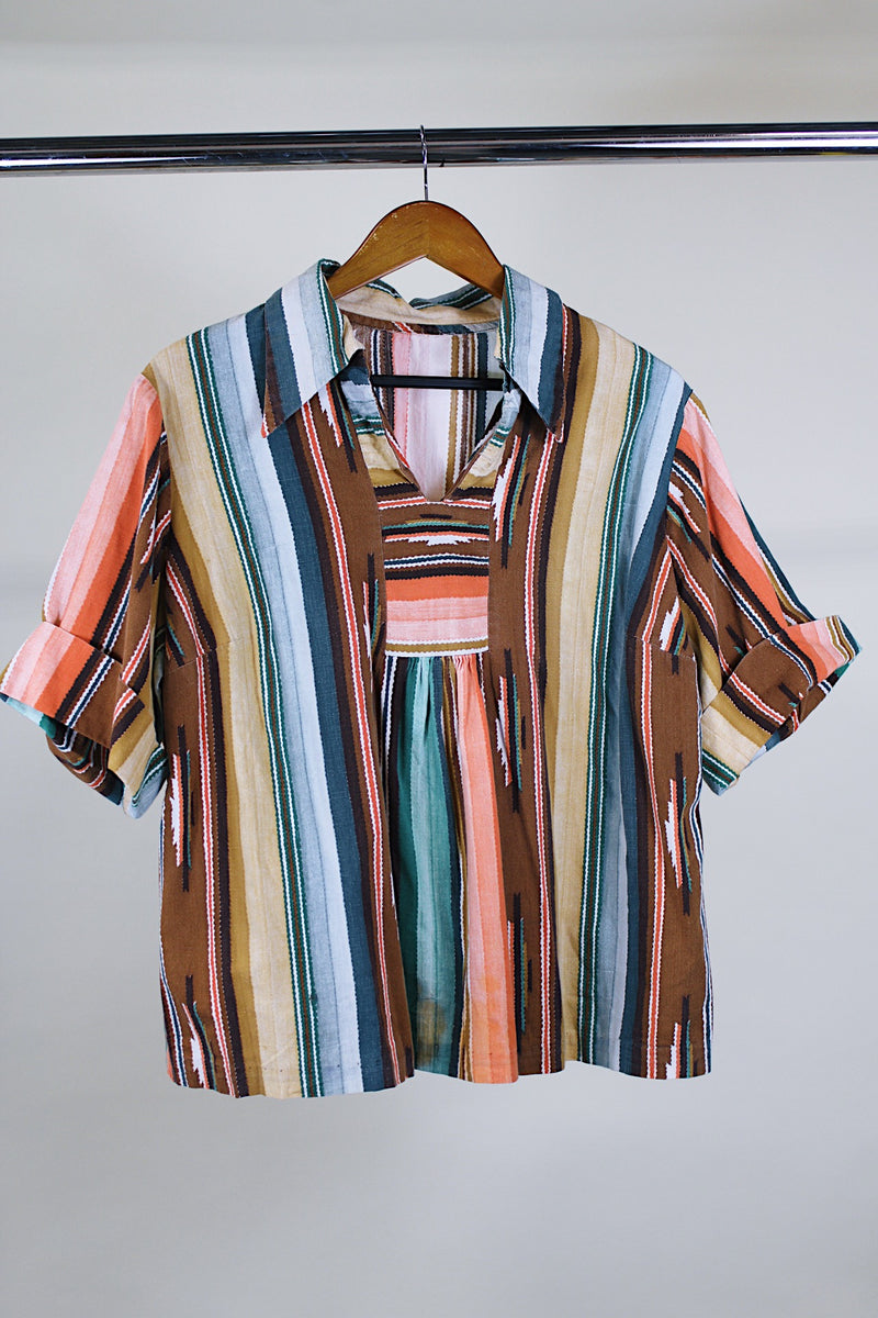Women's vintage western style 1980's short sleeve pullover blouse in green, peach, and brown vertical striped patterns. Collar and V shaped neckline.