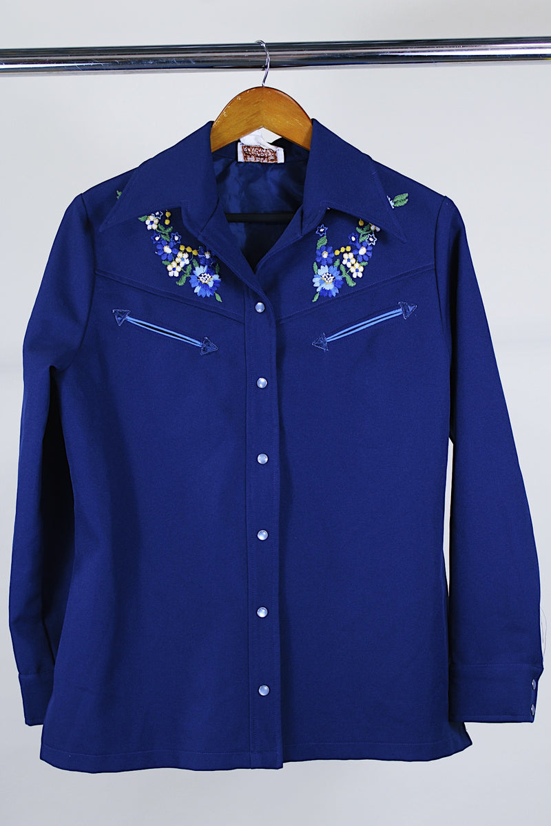 Women's vintage western style 1970's California Ranchwear label long sleeve navy blue blouse with pointy collar and pearly blue popper buttons. Has floral embroidery on shoulders.
