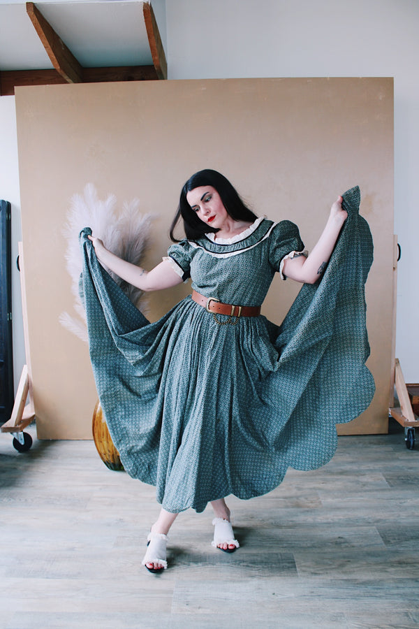 Women's vintage 1940's short sleeve maxi length cotton material prairie style dress with white and black ribbon trim around neckline and cuffs. Scalloped hem.