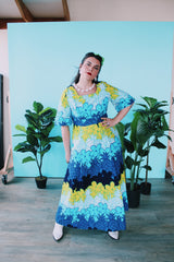 Women's vintage 1970's Sears Hawaiian Fashions label short sleeve maxi length cotton material Hawaiian print dress in green, blue, and white print with a square neckline.