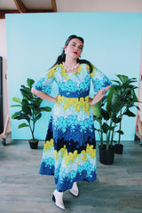 Women's vintage 1970's Sears Hawaiian Fashions label short sleeve maxi length cotton material Hawaiian print dress in green, blue, and white print with a square neckline.