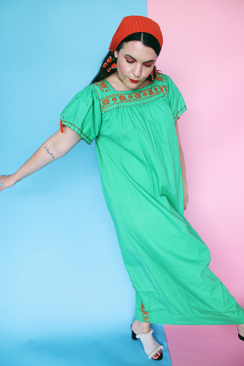 Women's vintage 1970's short sleeve cotton material green short sleeve ankle length dress with orange embroidery and a square neckline and puff sleeves.