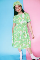 Women's vintage 1960's Martha Manning Original label short sleeve midi length green floral print dress with matching belt and pleated skirt bottom.