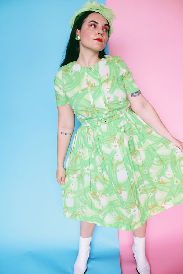 Women's vintage 1960's Martha Manning Original label short sleeve midi length green floral print dress with matching belt and pleated skirt bottom.
