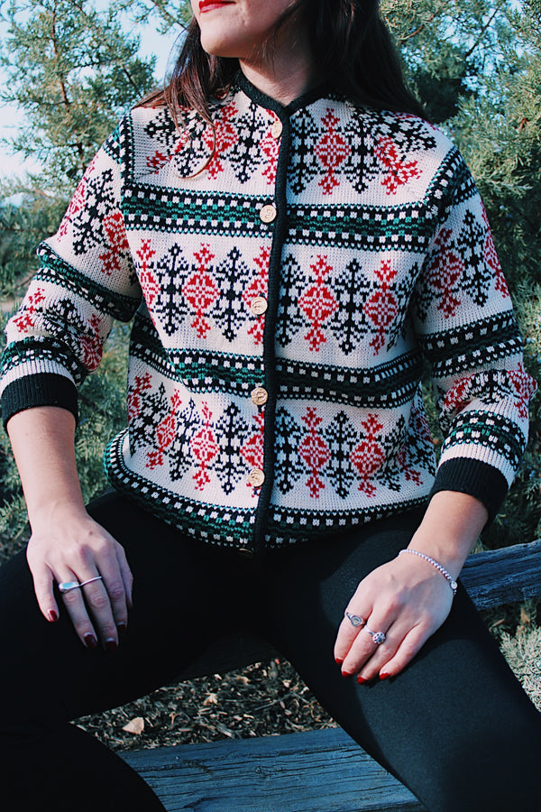 long sleeve wool sweater cream with red, green, and black print gold buttons up the front 