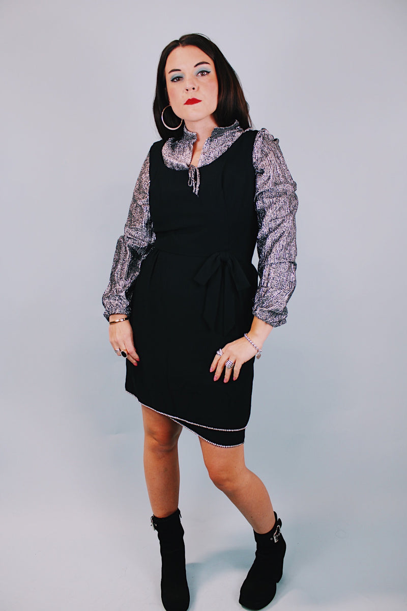 sleeveless scoop neck black mini dress with bow at waist and three tier skirt each with diamond hem 1960's vintage 