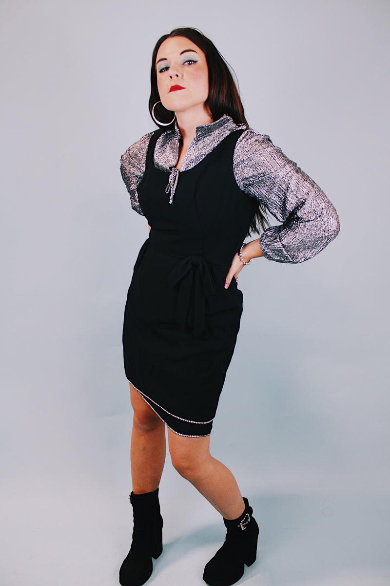 sleeveless scoop neck black mini dress with bow at waist and three tier skirt each with diamond hem 1960's vintage 