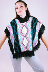 1980's vintage women's acrylic knit poncho with black fringe hem