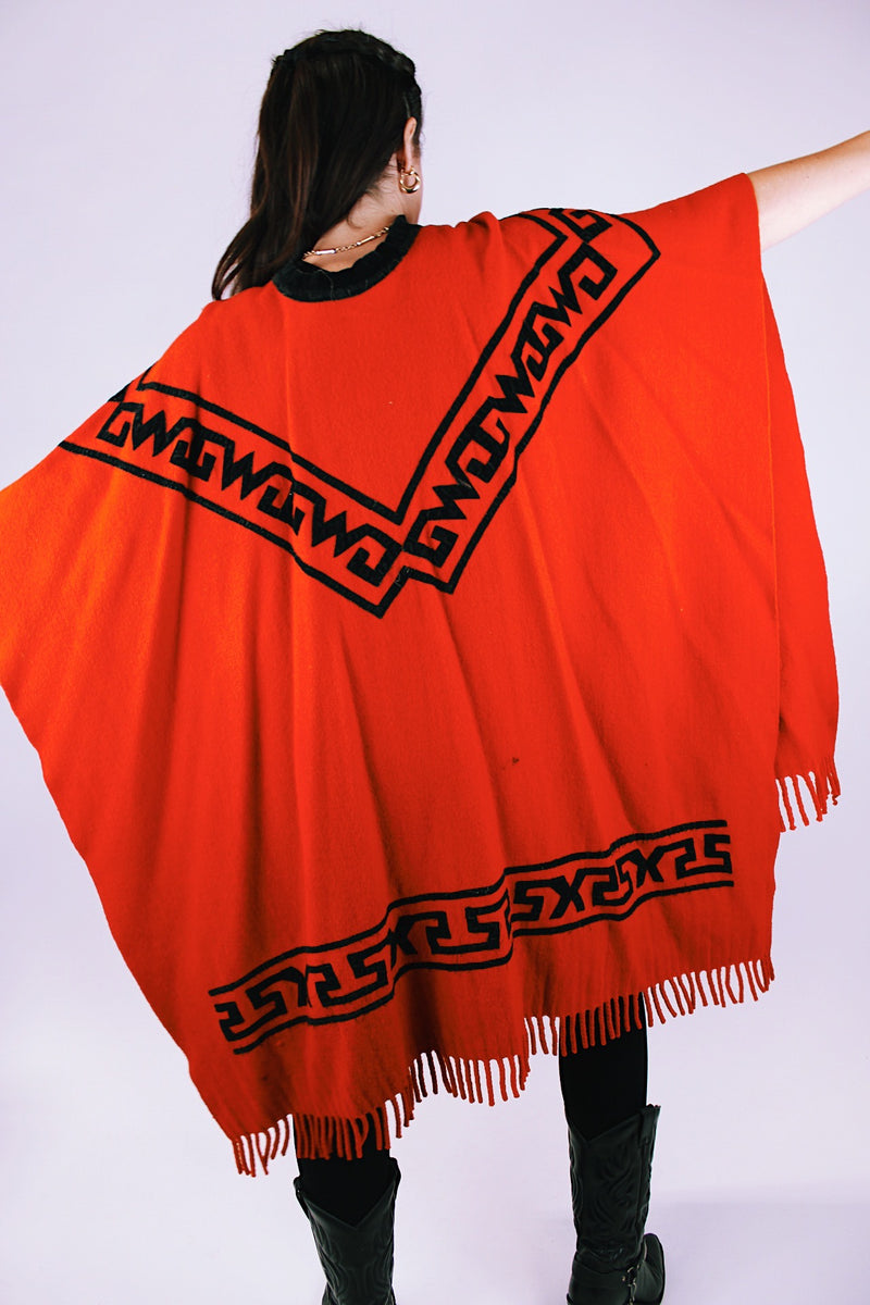 1970's vintage red wool poncho with abstract velvet trim pattern and fringe hem