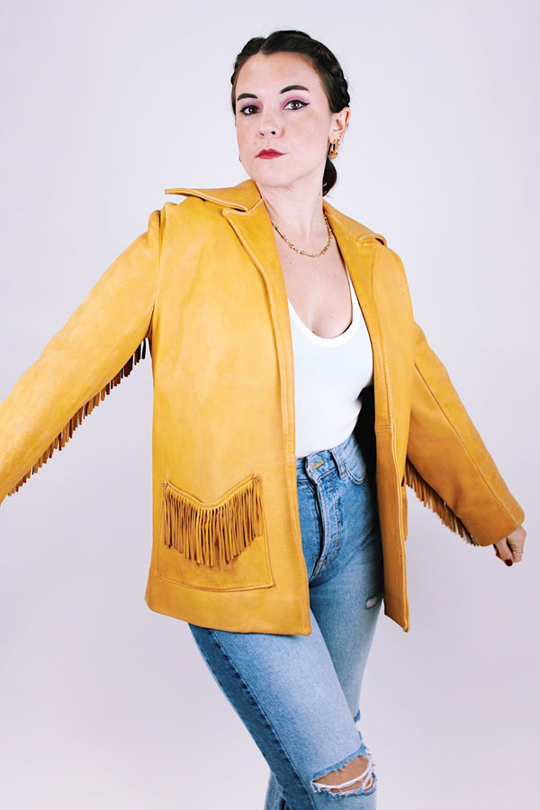 tan women's vintage 1970's genuine leather jacket with fringe, pockets, and double lapel 