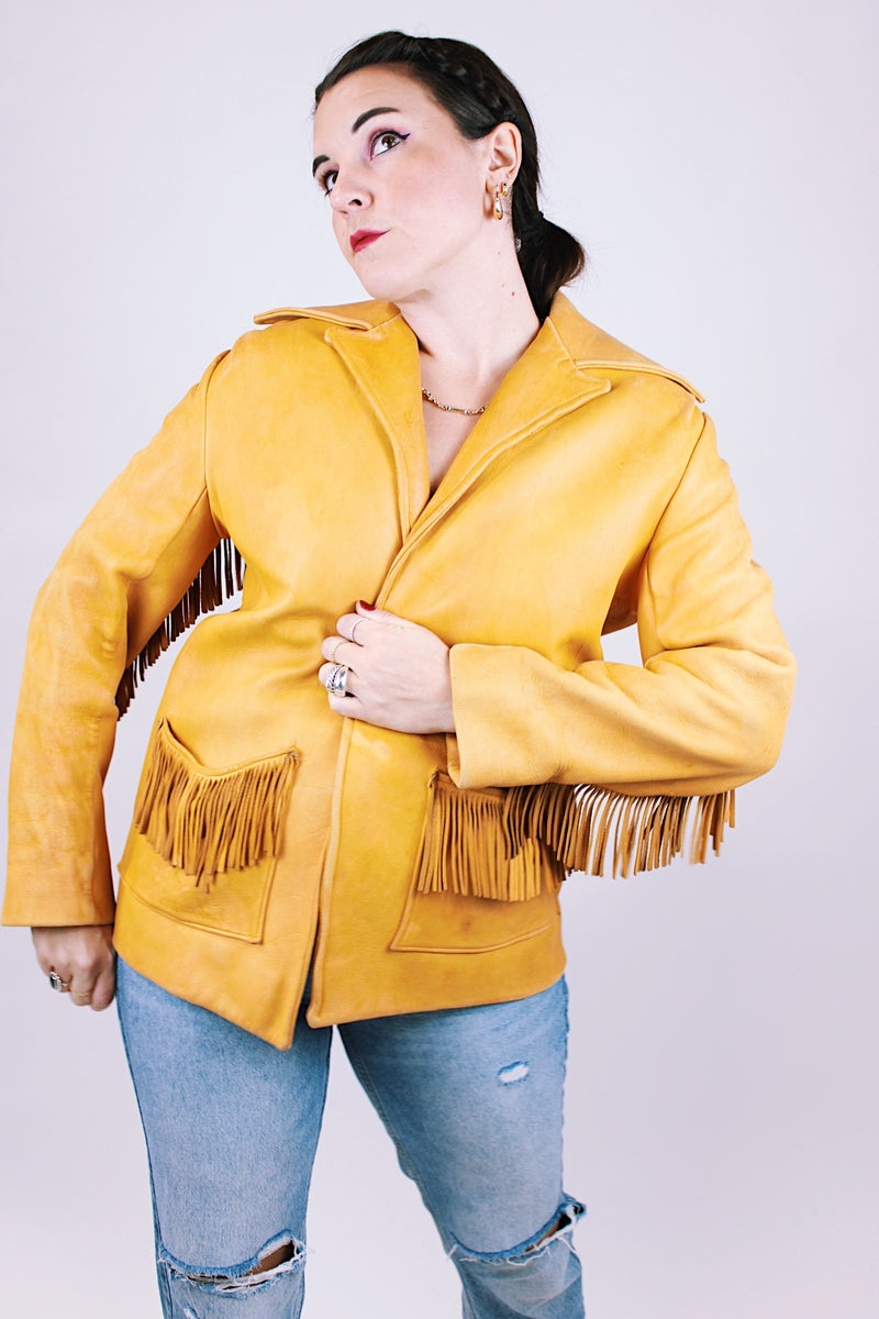 tan women's vintage 1970's genuine leather jacket with fringe, pockets, and double lapel 